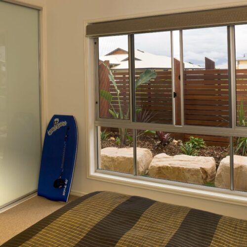 View Through a Bedroom Window Showing a Wooden Fence — Suburban Security Screens in Currumbin, QLD