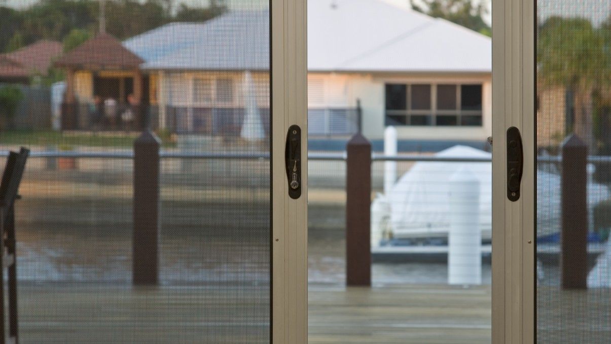 A View Through Screen Doors of A Waterfront Home — Suburban Security Screens in Currumbin, QLD