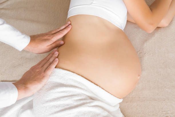 A pregnant woman is getting a massage from a man.