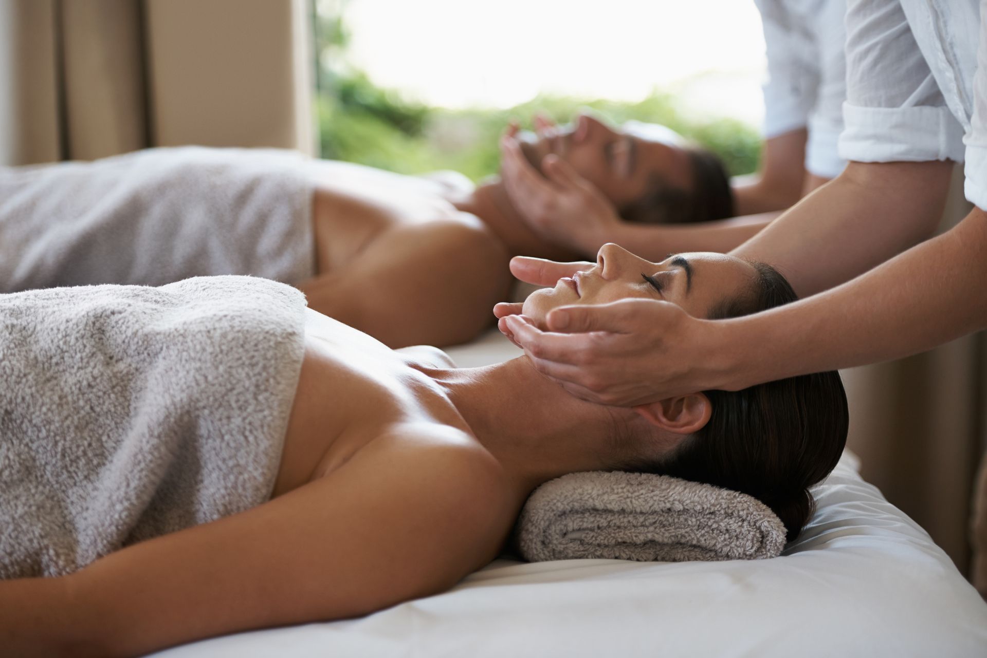 A man and a woman are getting a massage at a spa.