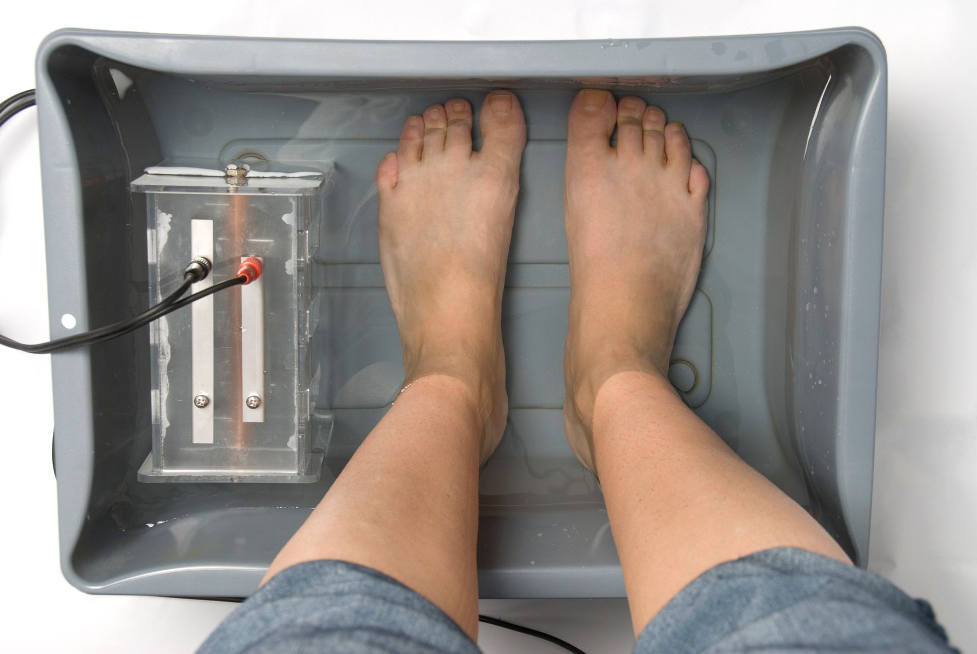 A person 's feet are in a tray of water