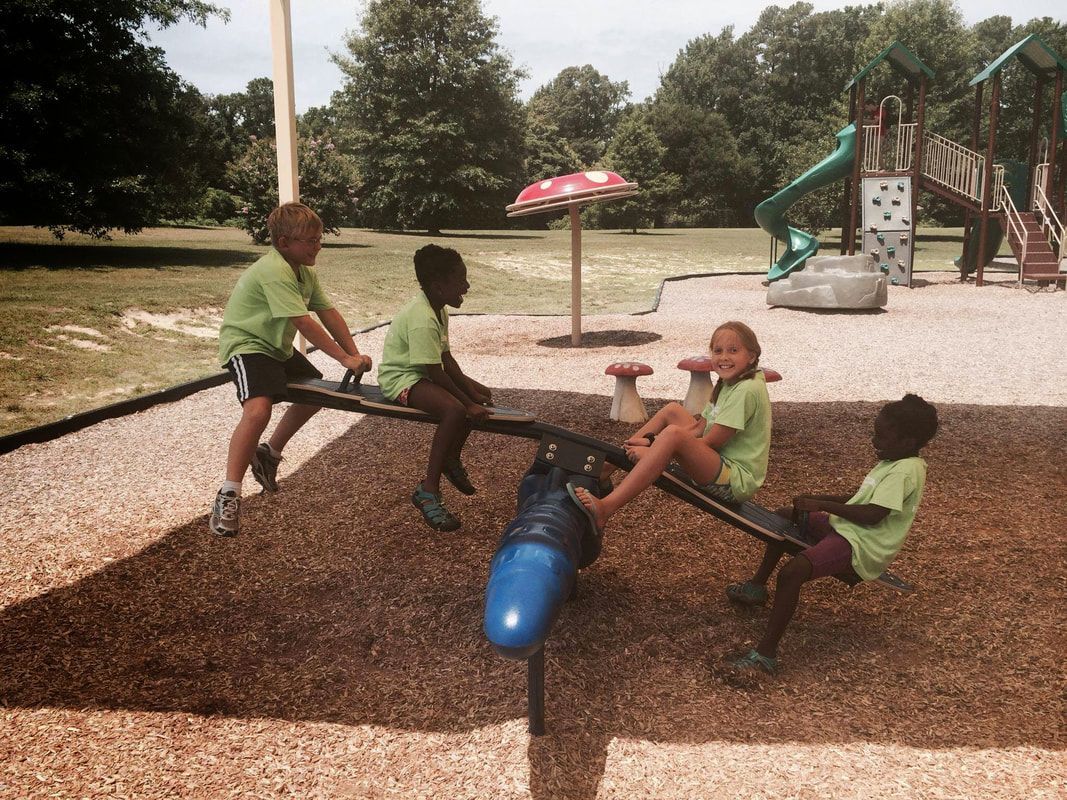 A group of children are playing on a seesaw in a park.