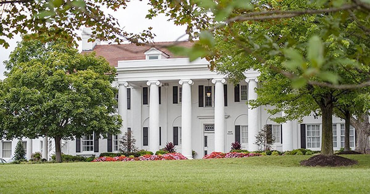 A woman holding a piece of paper that says olddominion
