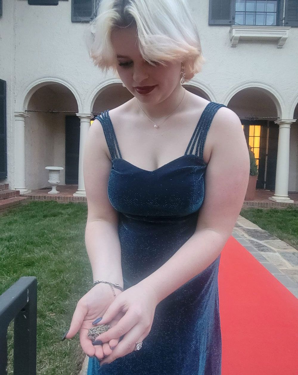 A woman in a blue dress is standing on a red carpet