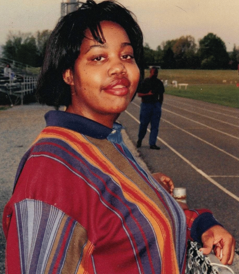 A woman in a striped shirt is standing on a track