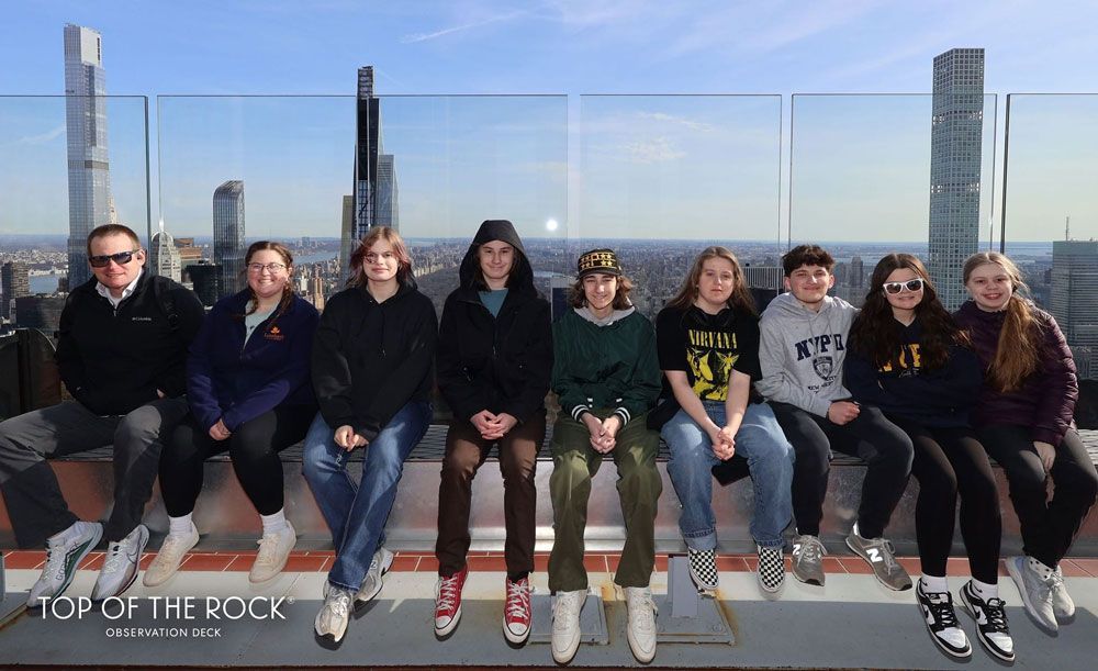A group of people are sitting on top of a building.