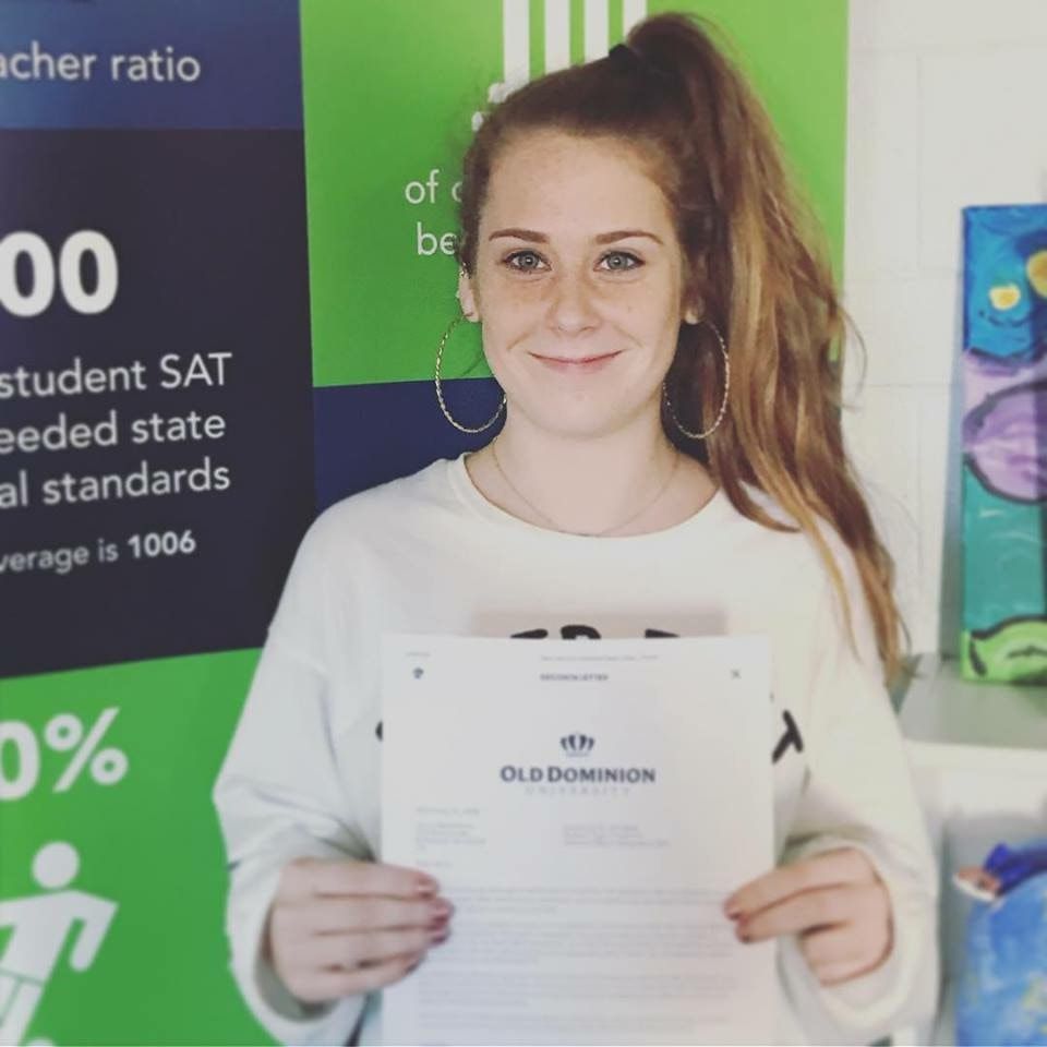 A woman holding a piece of paper that says olddominion