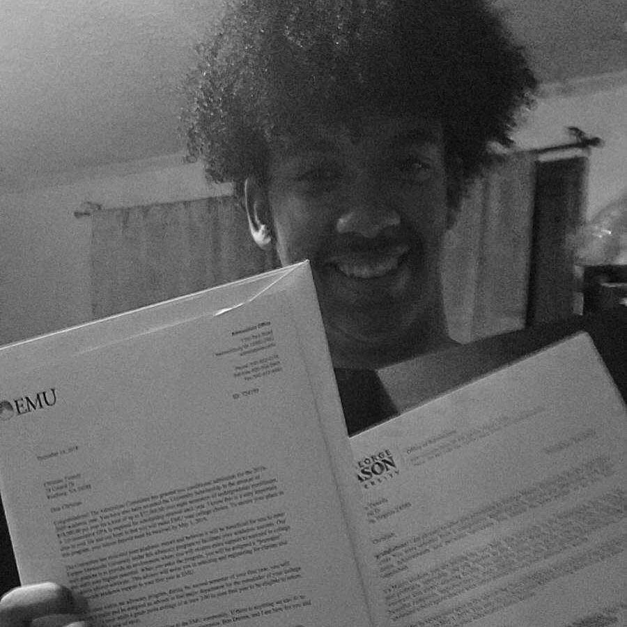 A black and white photo of a man holding a letter from emu