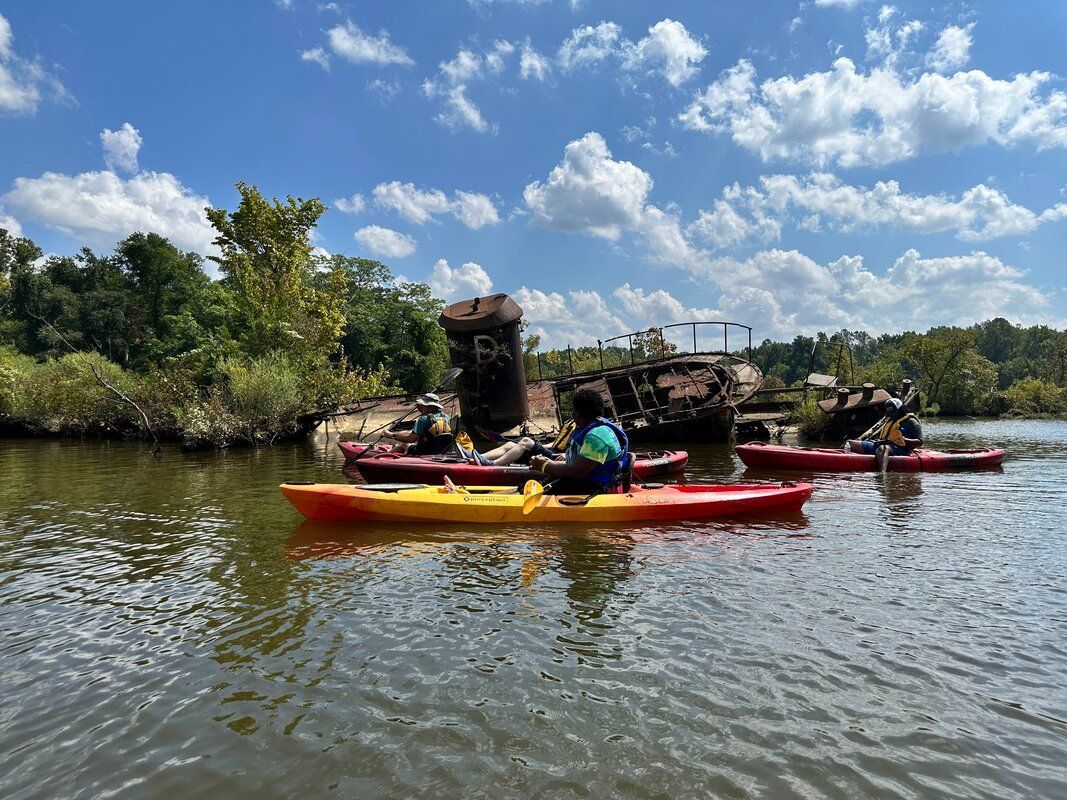 A group of people are riding kayaks on a lake.