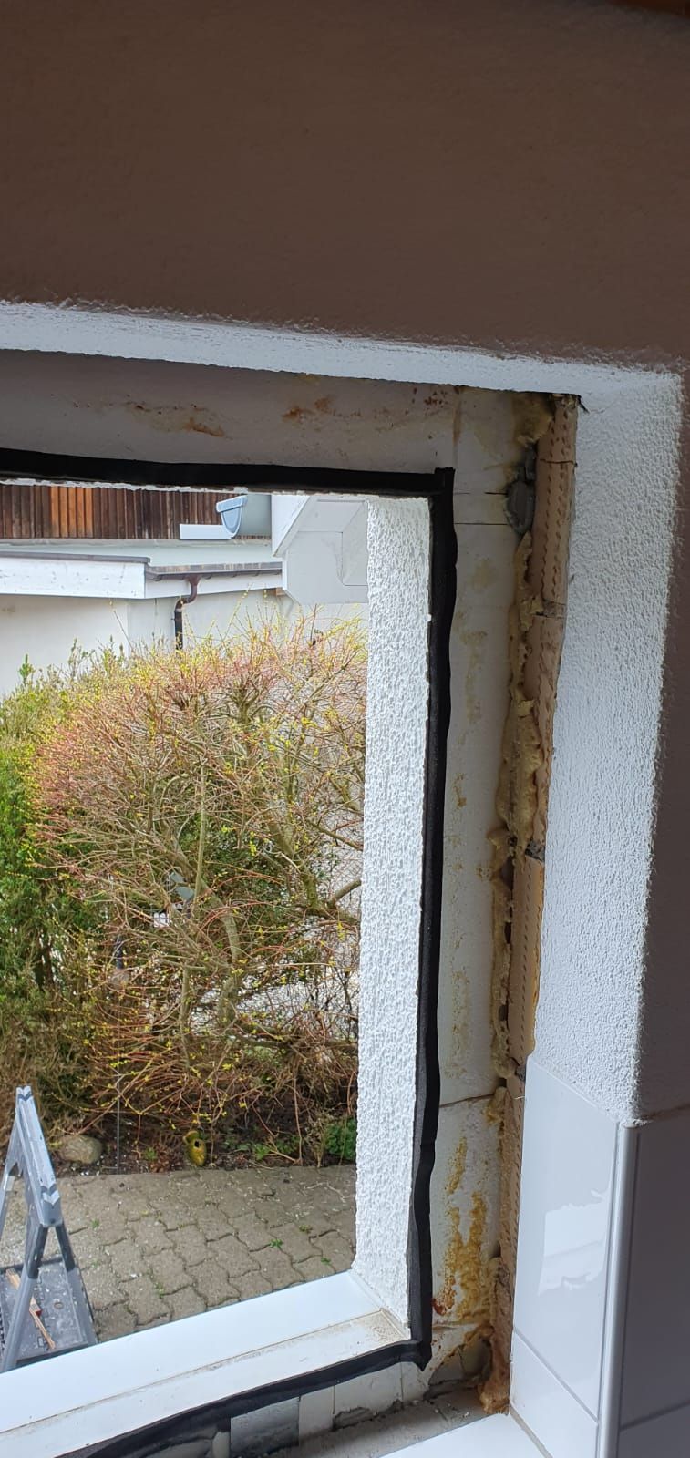 Ein Fenster in einer Küche mit Blick auf einen Garten.