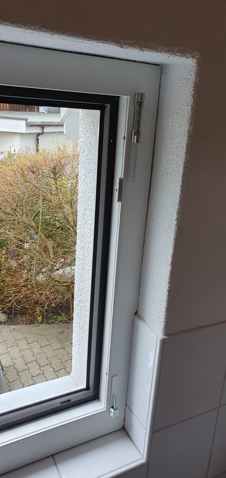 Eine Nahaufnahme eines Badezimmerfensters mit Blick auf einen Garten.