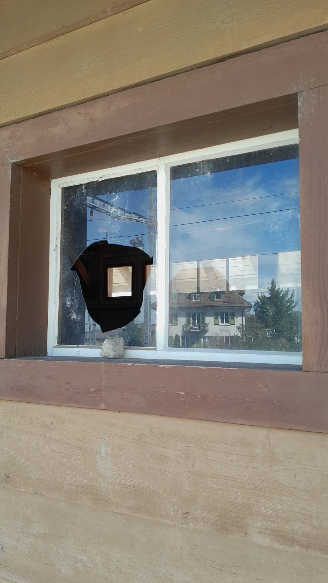 Ein Fenster an einem Gebäude mit einem schwarzen Objekt darin.