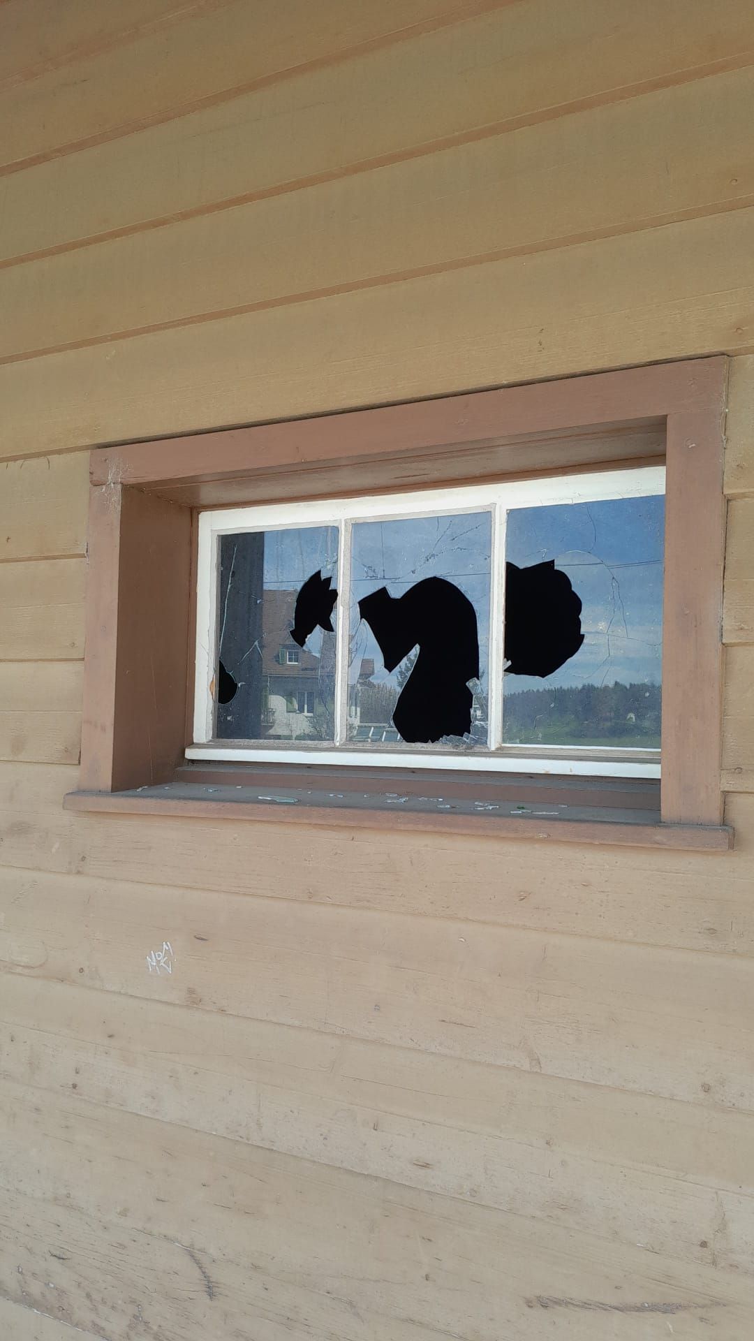 Ein zerbrochenes Fenster an der Seite eines Gebäudes.