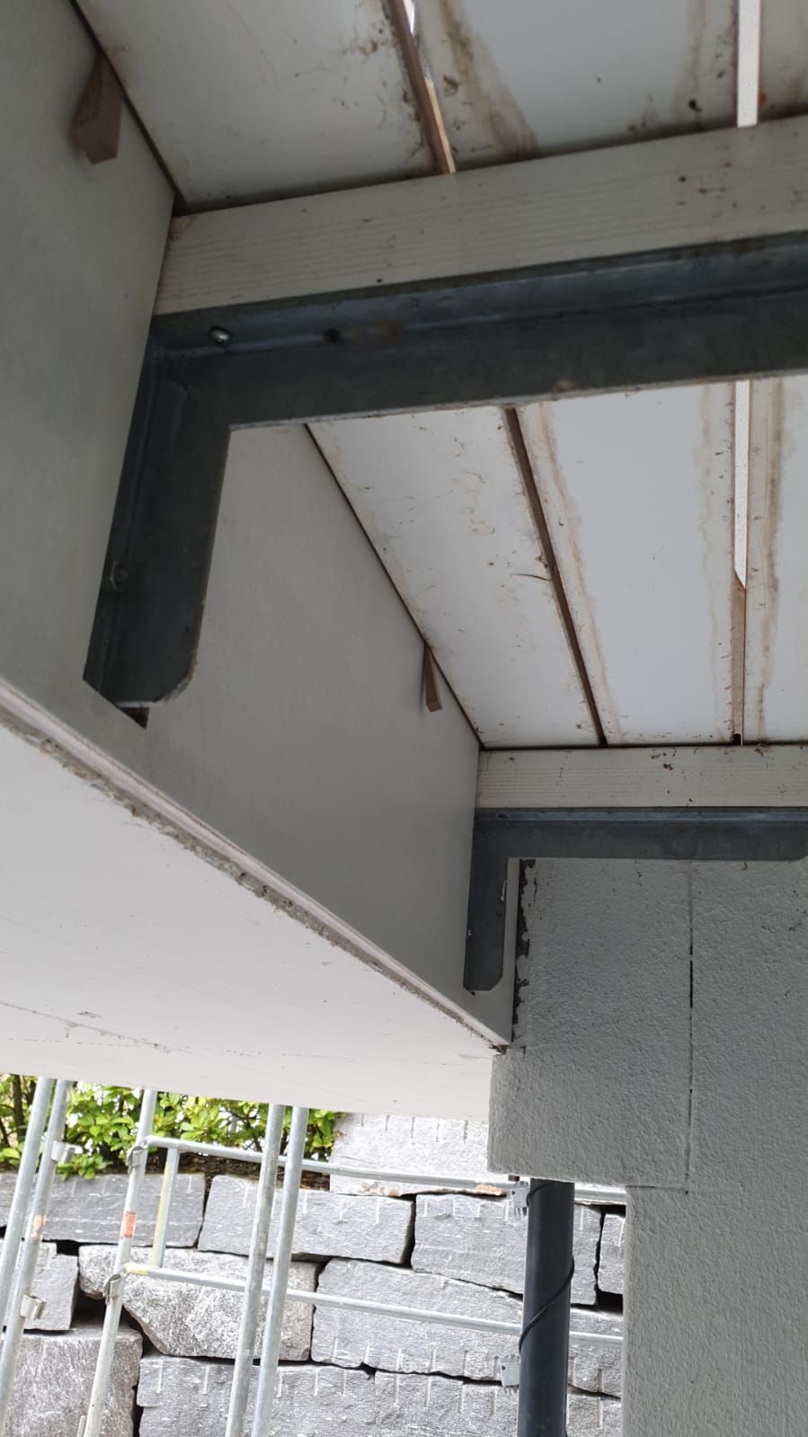 Eine Nahaufnahme eines Daches mit einer Ziegelmauer im Hintergrund.