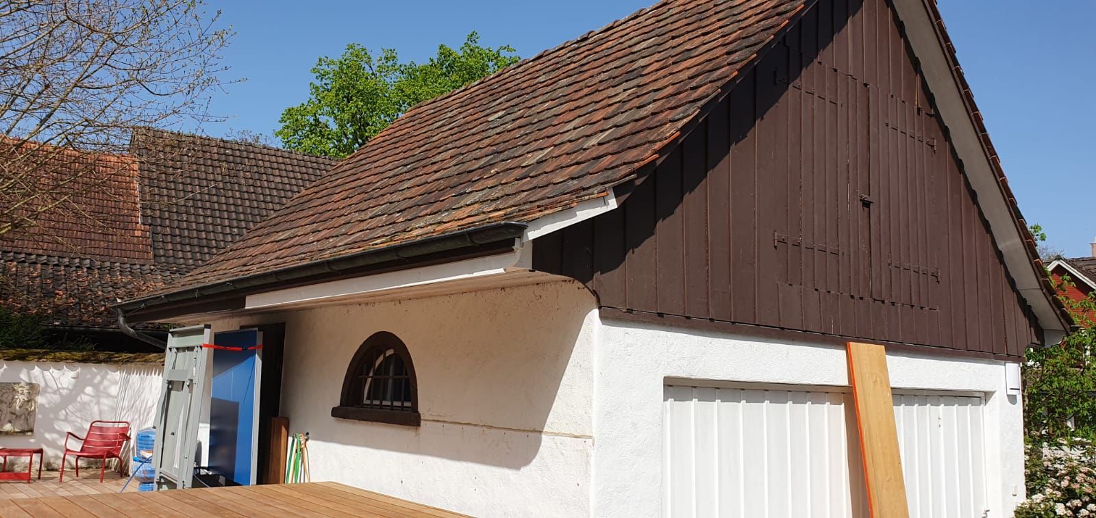 Auf einem Erdhügel steht ein kleines weißes Haus mit braunem Dach.