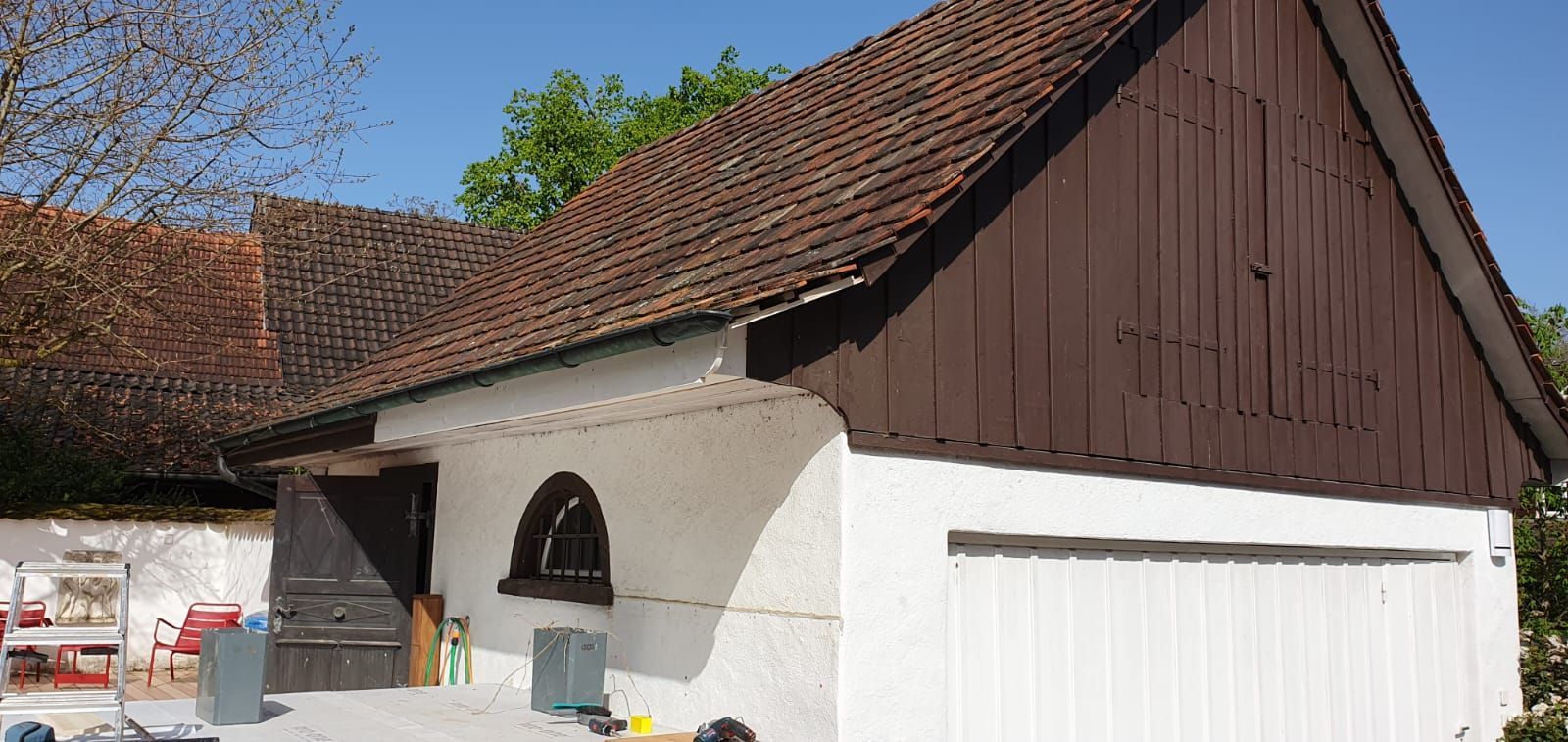 Ein weisses Gebäude mit einem braunen Dach und einem Fenster