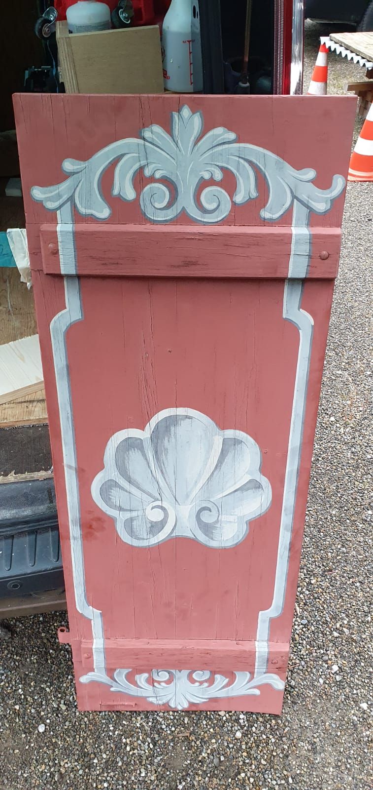 Auf dem Boden steht ein rot-weißer Schirmständer mit einer Muschel darauf.