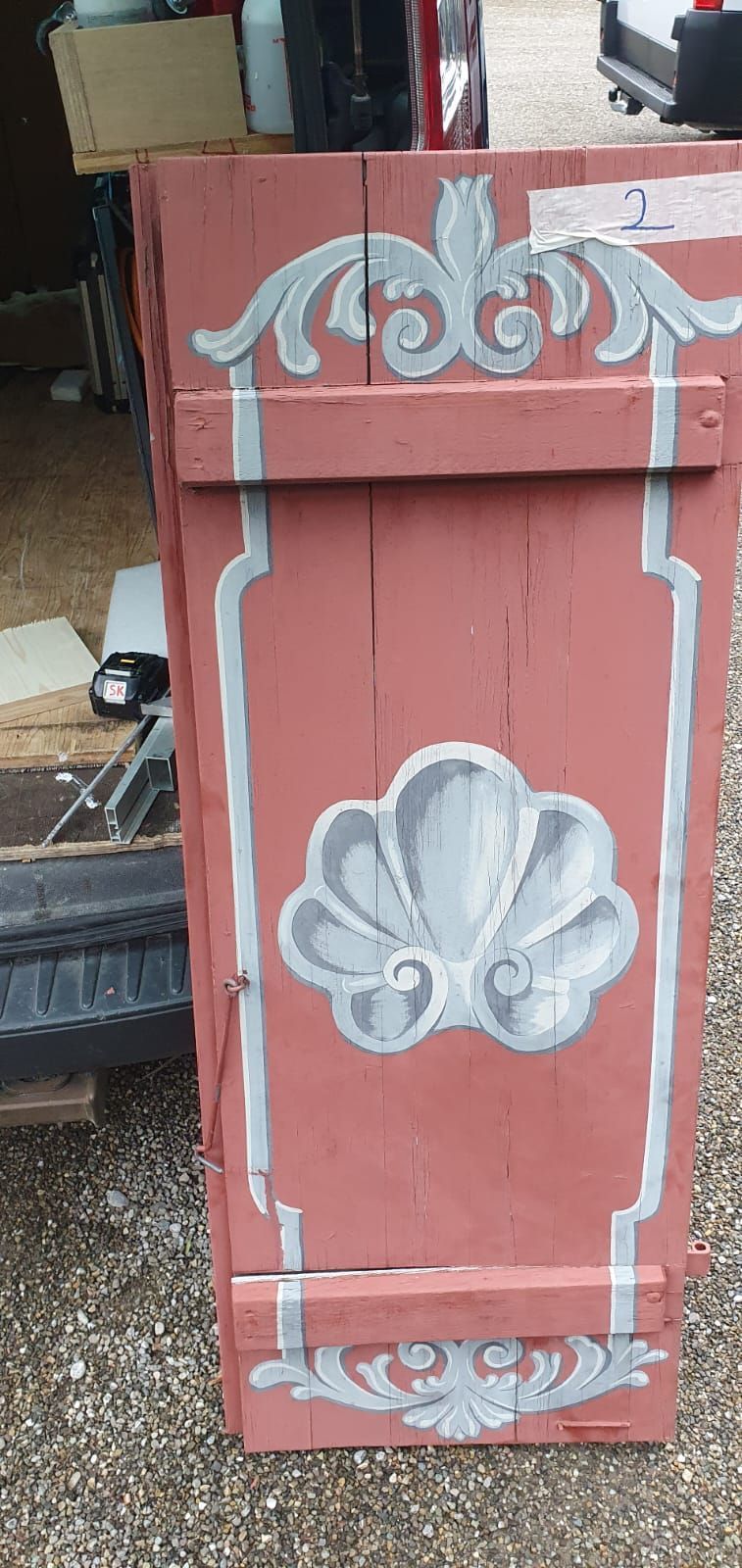 Auf dem Boden steht eine rote Holzkiste mit einem weissen Muster.