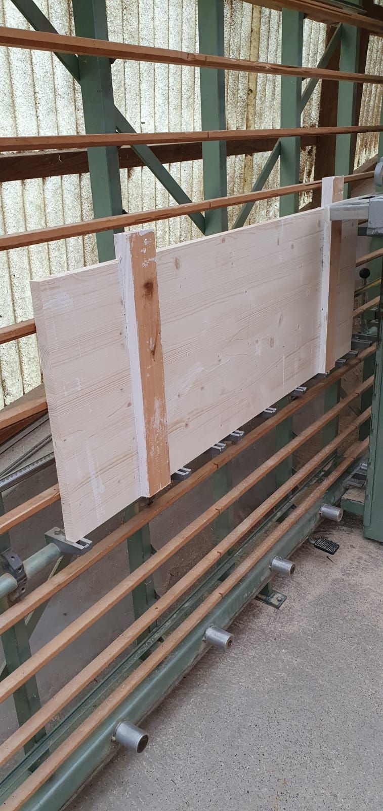 Auf einer Maschine liegt ein großes Stück Holz.