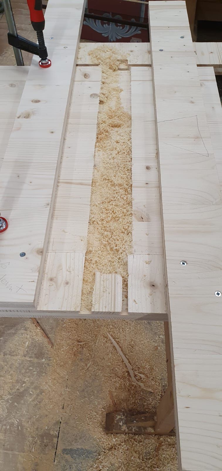 Eine Person schneidet mit einem Bohrer ein Stück Holz.