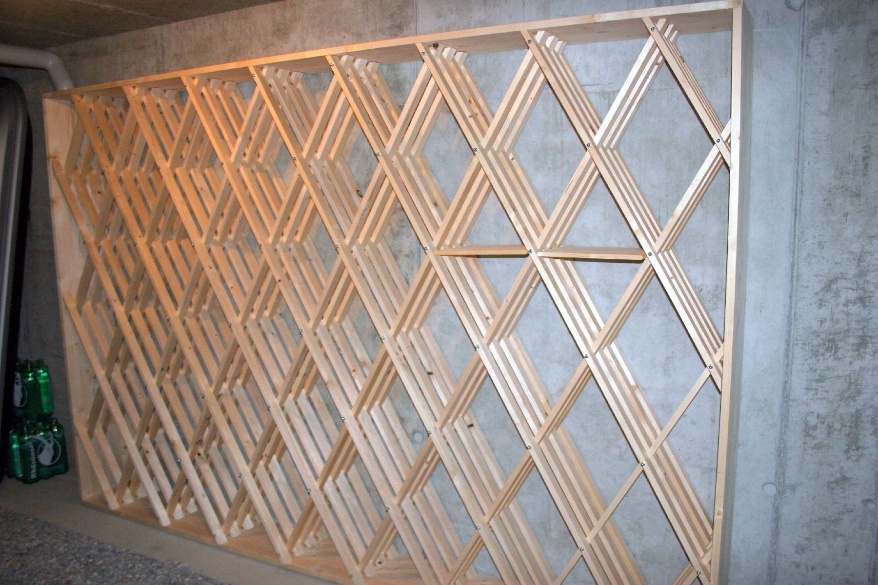 Ein grosses Weingestell steht an einer Betonwand