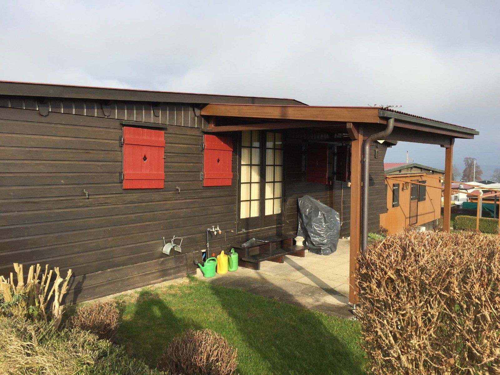 Ein kleines Holzhaus mit roten Fensterläden