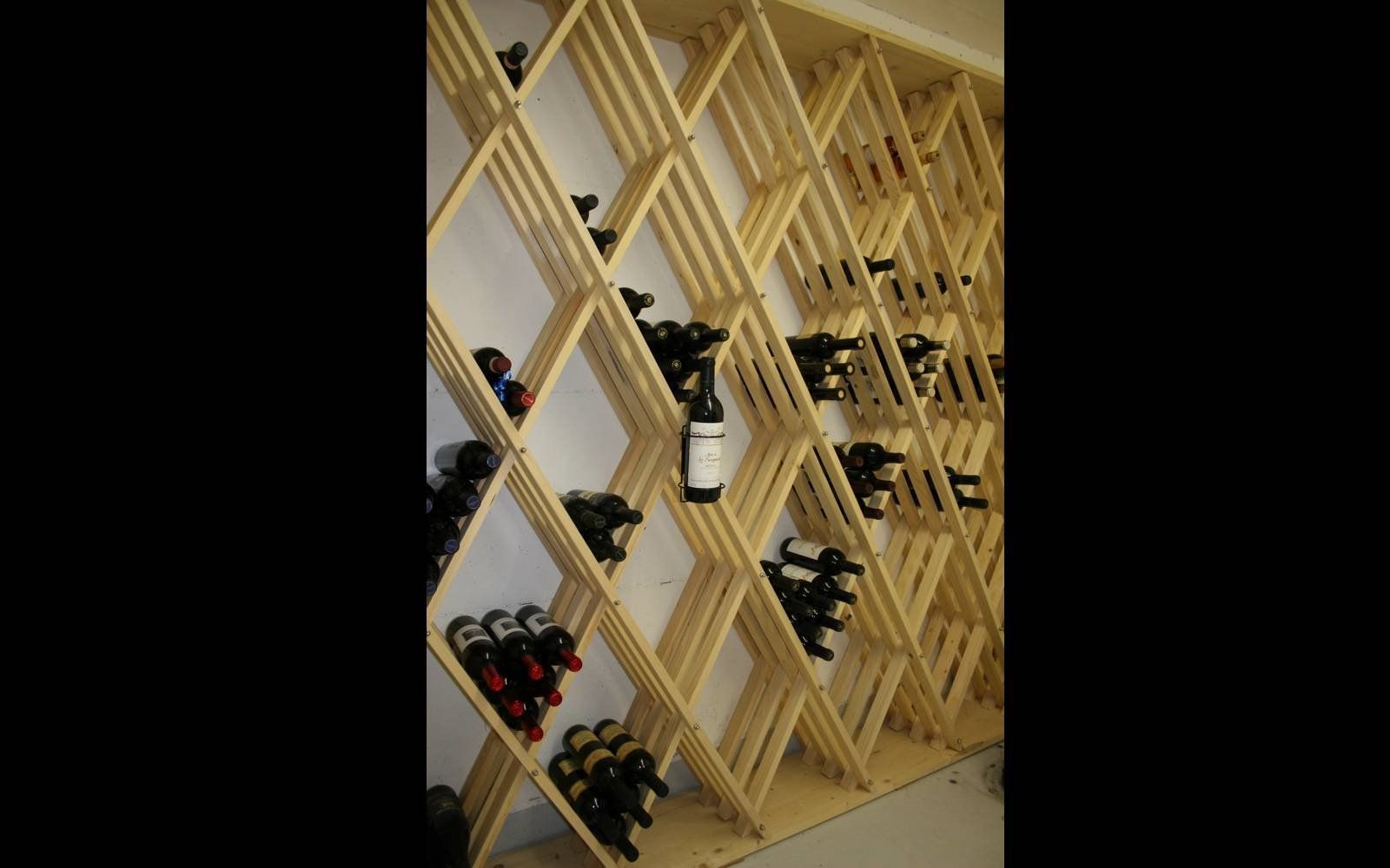 Eine Flasche Wein liegen auf einem hölzernen Weinregal.