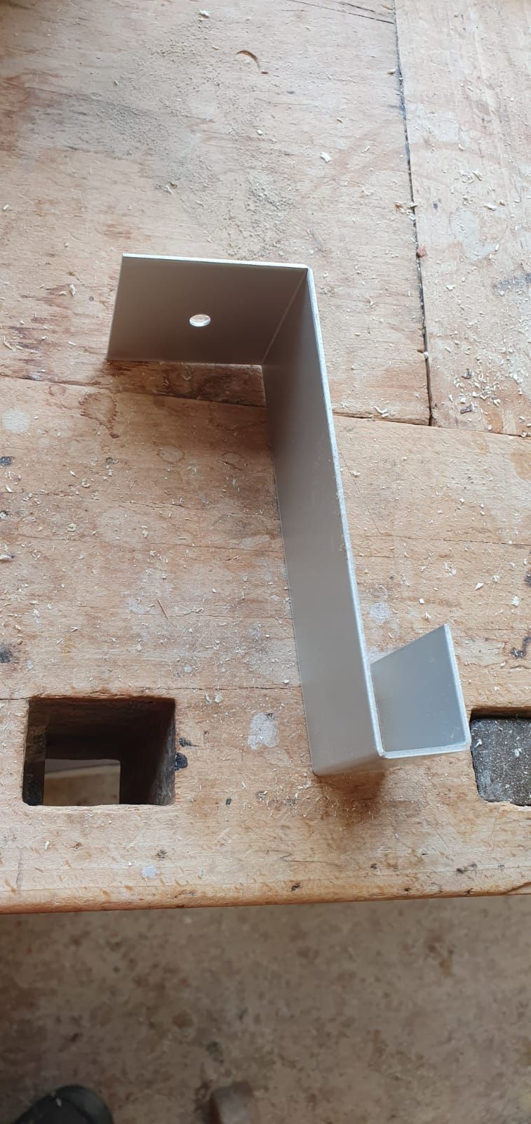 Auf einem Holztisch liegt ein Stück Metall.