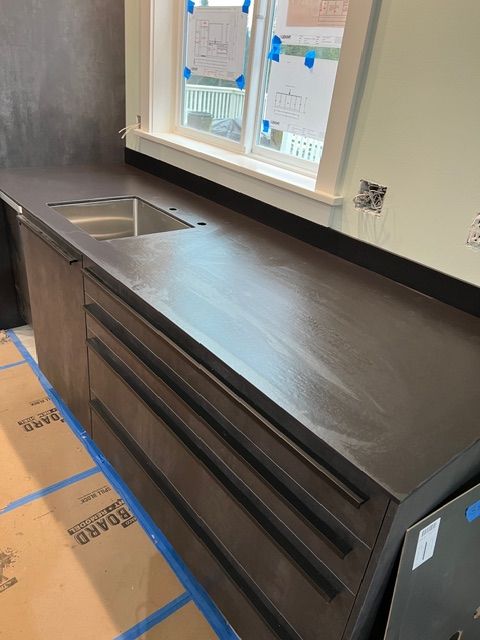 Modern kitchen with dark brown cabinets, a matching countertop, and a stainless steel sink.