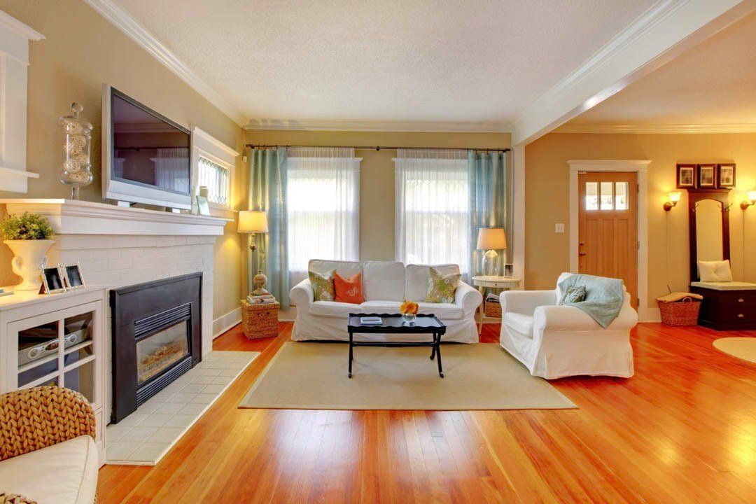 A living room with hardwood floors and a fireplace.