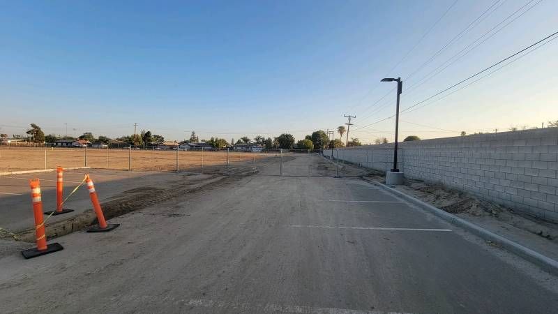 A dirt road with orange cones on the side of it.