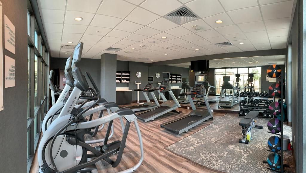 A large gym with a lot of treadmills and ellipticals.