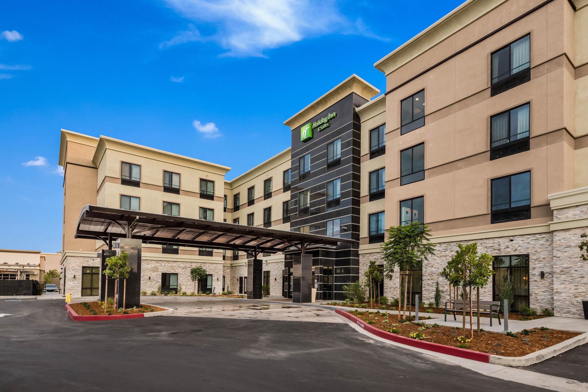 A large hotel with a lot of windows and a parking lot in front of it.