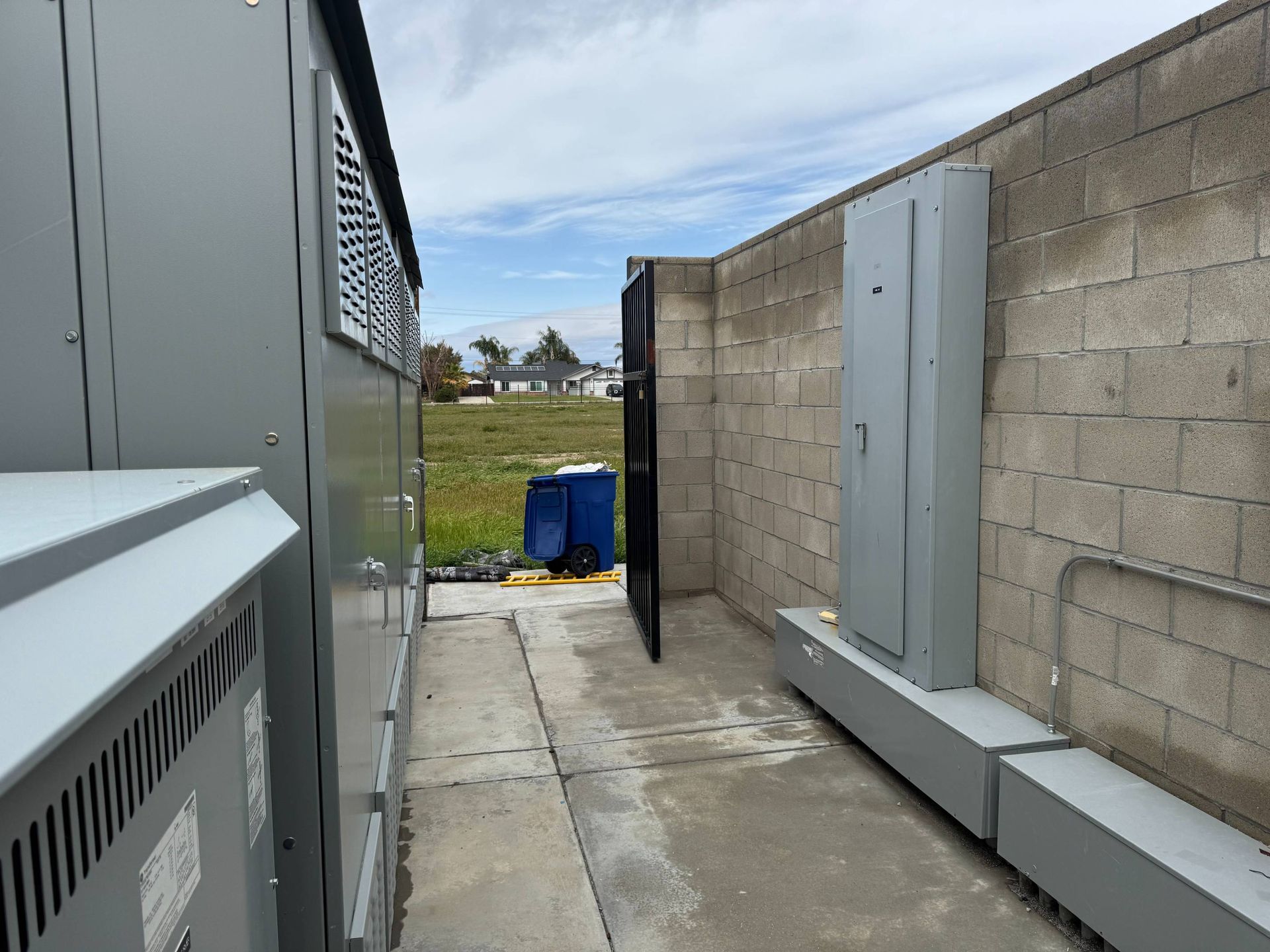 A narrow walkway between two buildings with a brick wall.