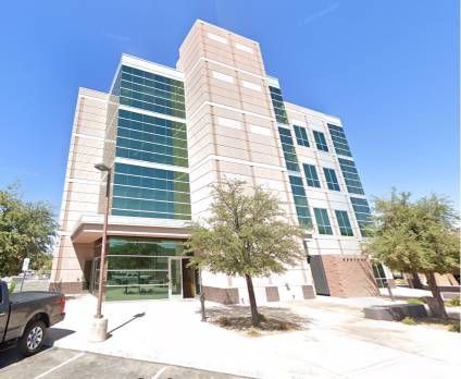 A large building with a lot of windows and a truck parked in front of it.