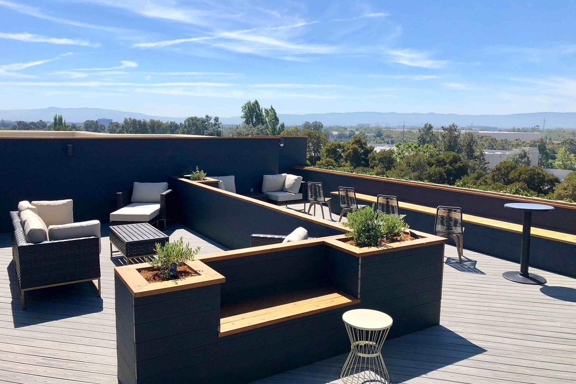 A rooftop patio with a view of the city and mountains
