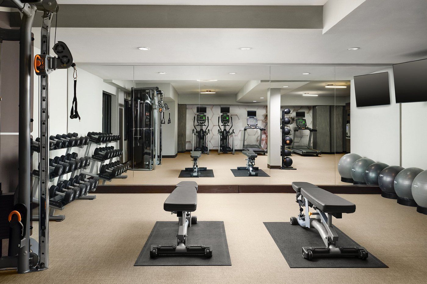 A gym with a lot of equipment and a large mirror