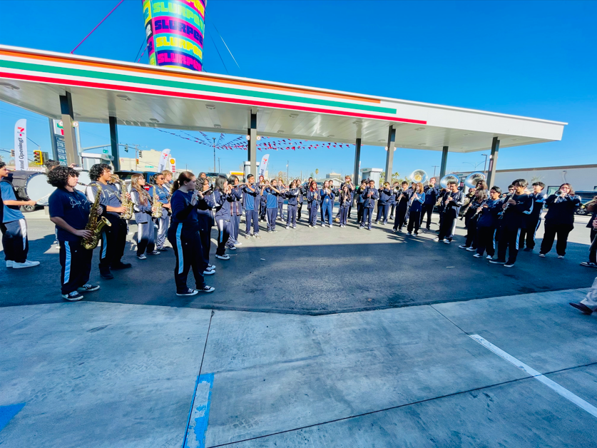 A group of people standing in front of a gas station