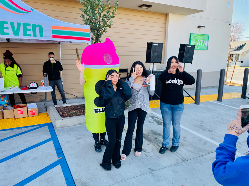A group of people standing in front of a 7 eleven