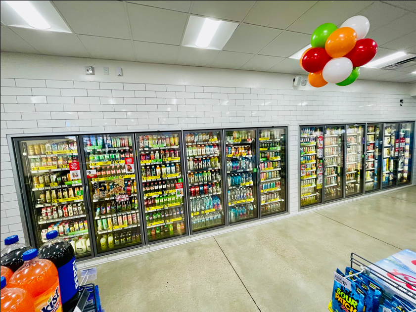 A store with a lot of fridges and balloons hanging from the ceiling