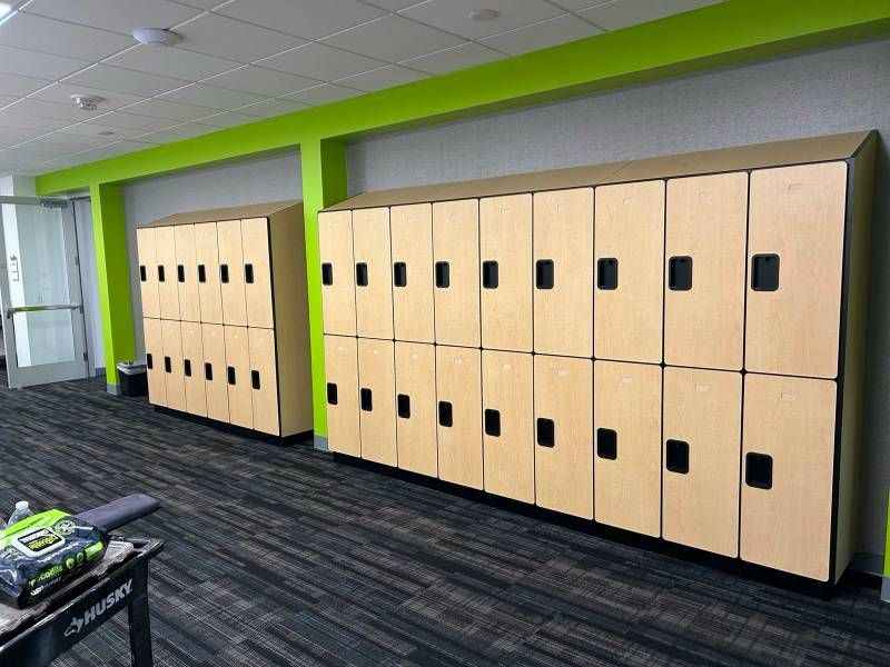 A row of wooden lockers in a room with green walls.