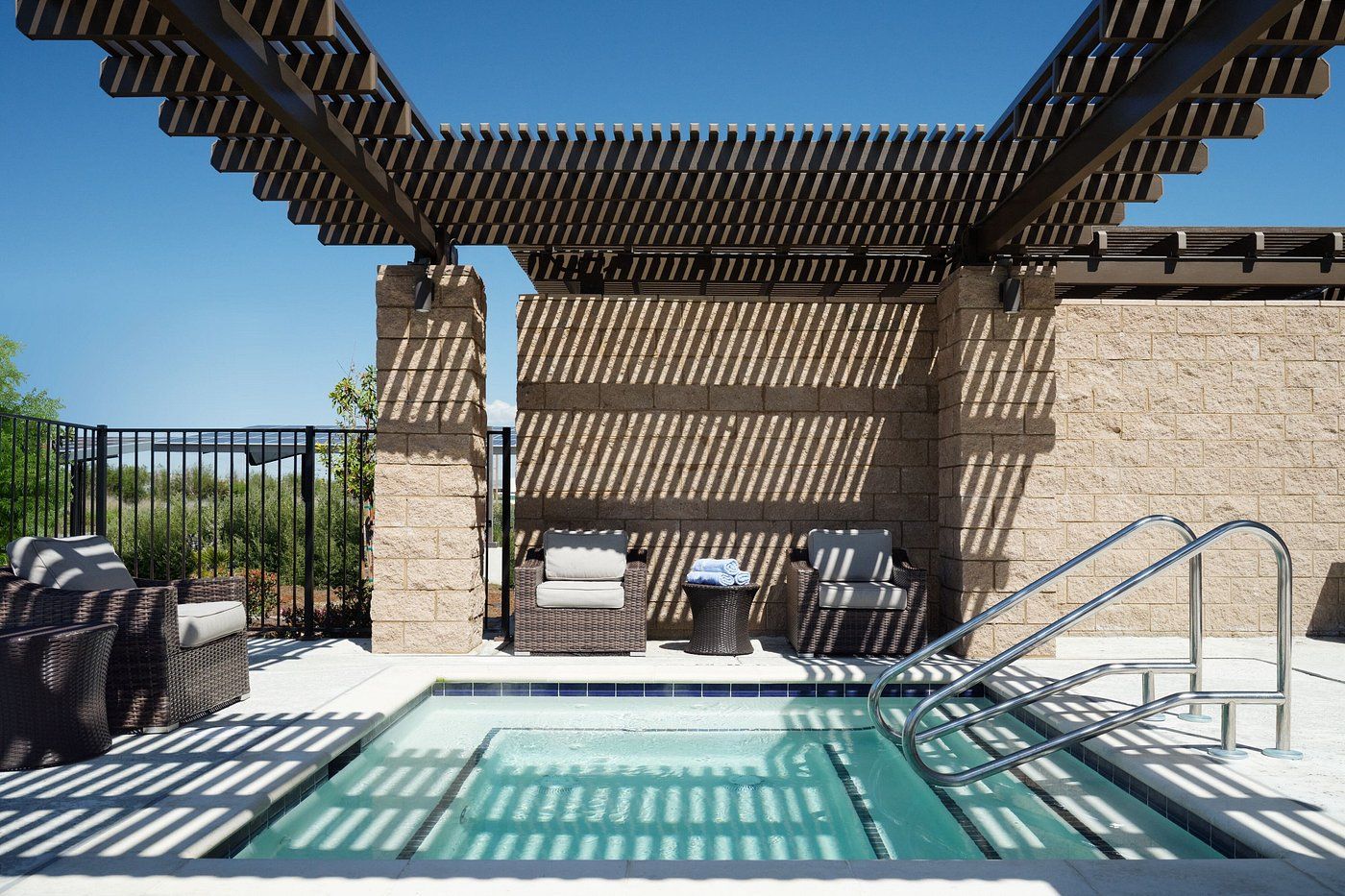 A large swimming pool with a pergola over it