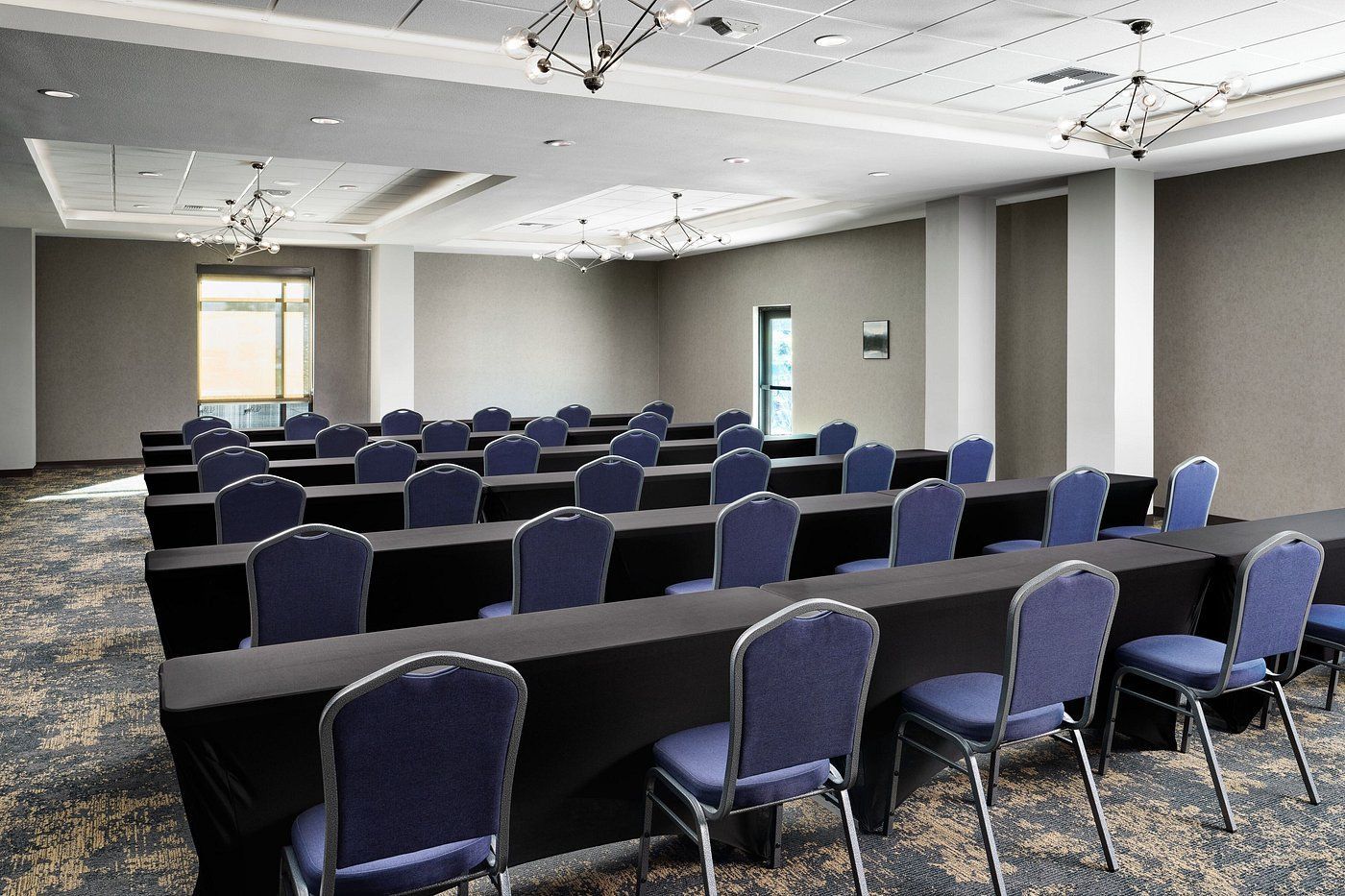 A large conference room with rows of tables and chairs.
