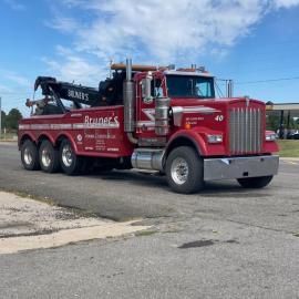 Red tow truck parked on asphalt. 