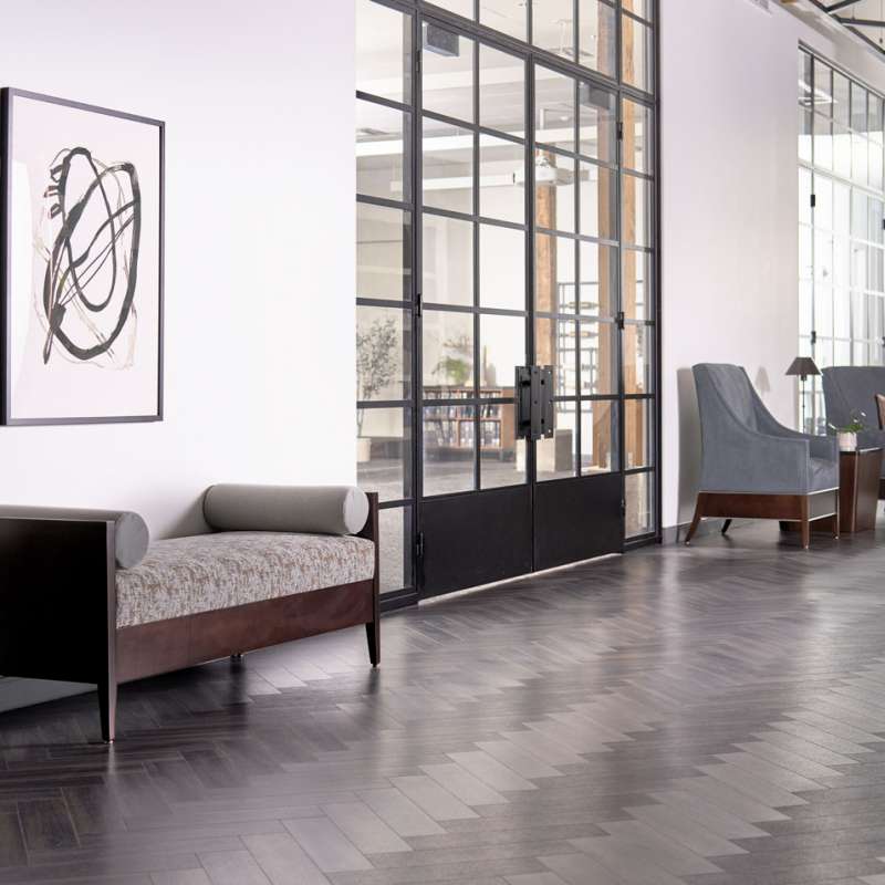 A living room with a bench and chairs and a painting on the wall