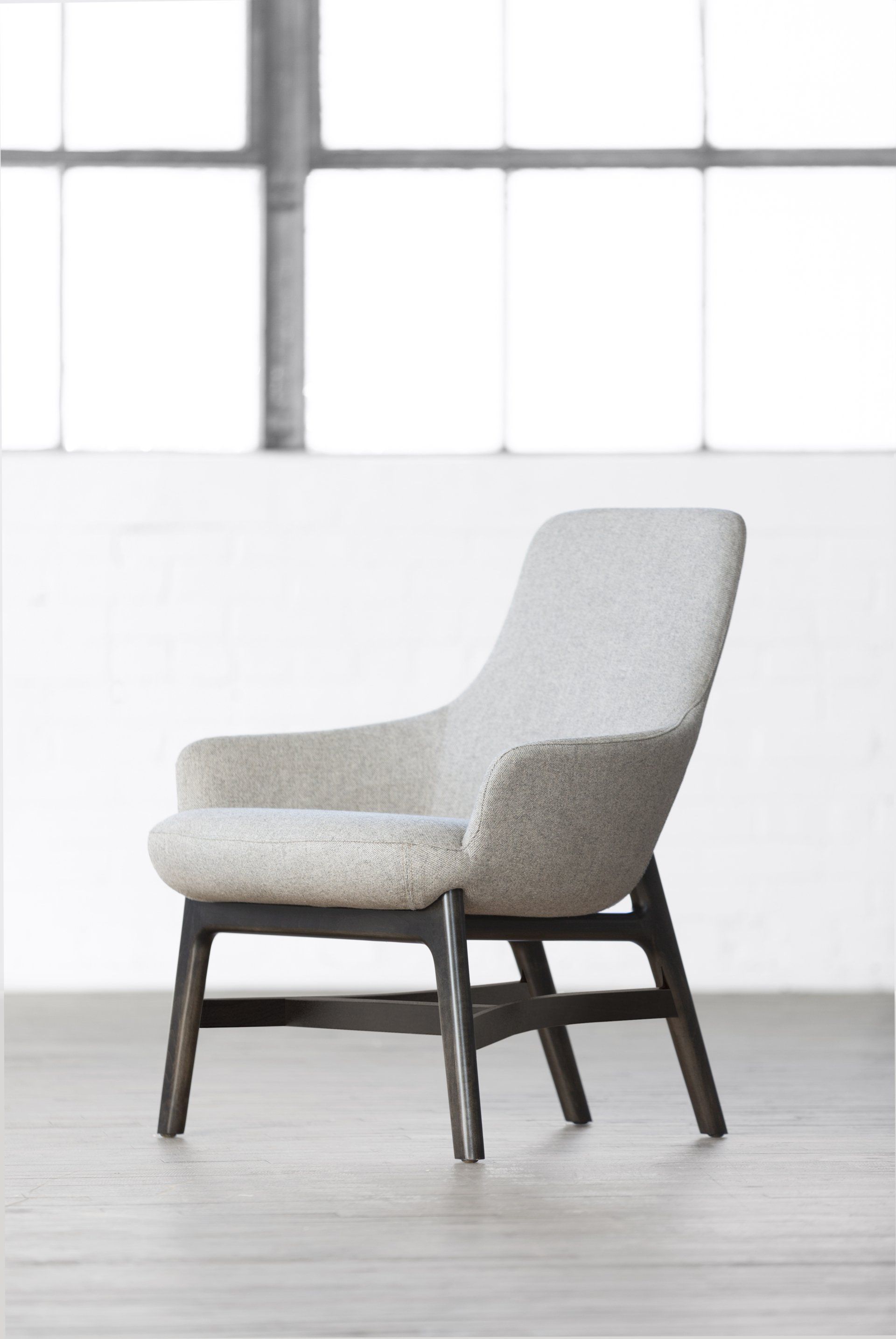 A white chair is sitting in front of a window in a room.