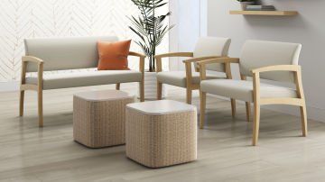 A living room with a couch , chairs , ottomans and a plant.