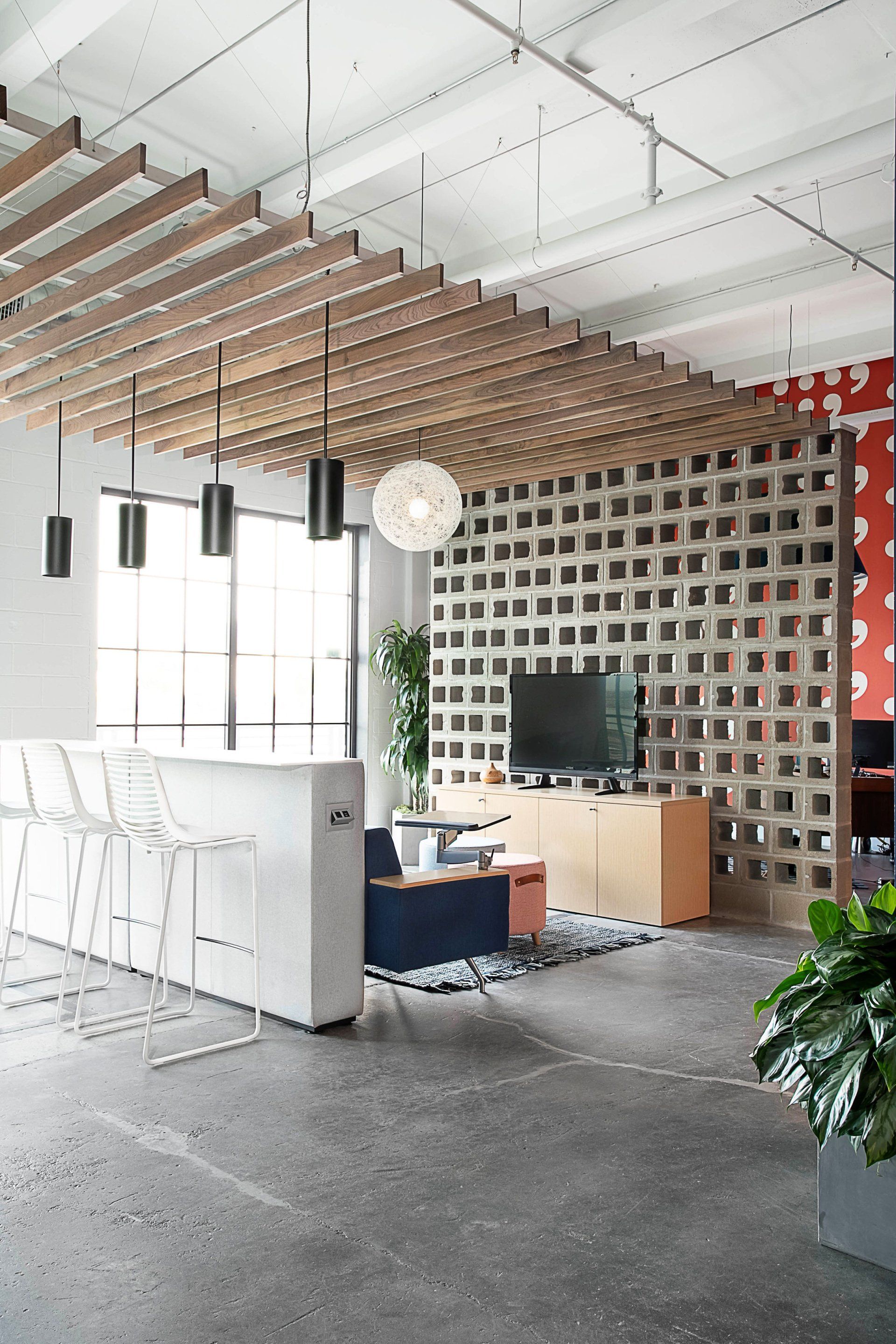 A living room with a wooden ceiling and a tv on the wall.