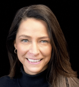 A woman wearing a black turtleneck is smiling for the camera