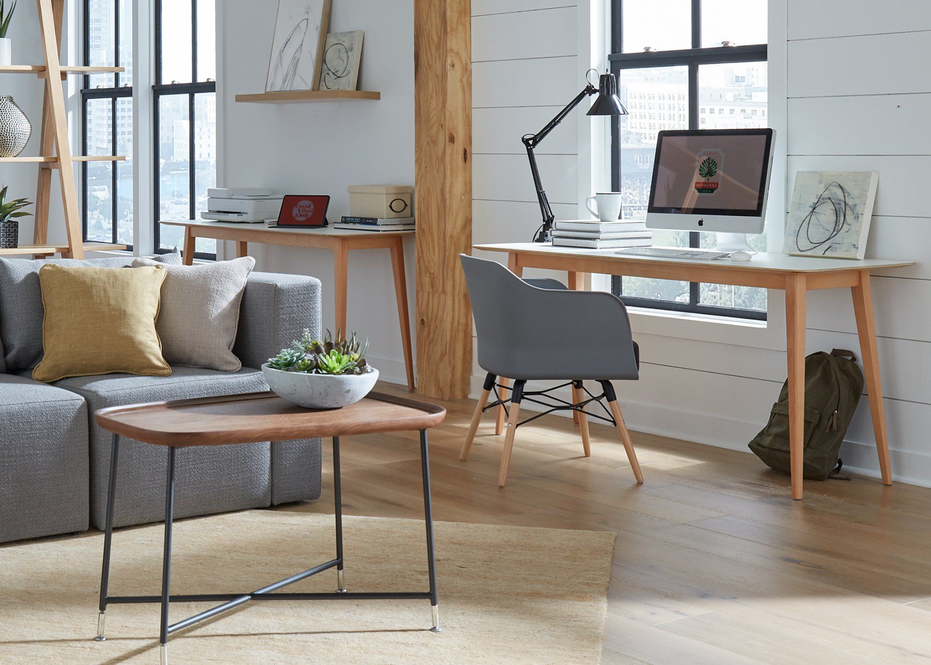 A living room with a couch , desk , chair and computer.